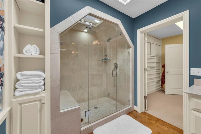 bathroom featuring a shower with door and hardwood / wood-style floors