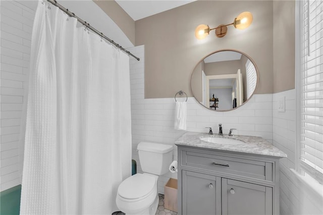 bathroom featuring vanity, toilet, tile walls, and curtained shower