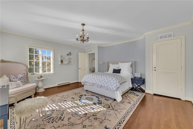 bedroom with ornamental molding, hardwood / wood-style floors, and a notable chandelier