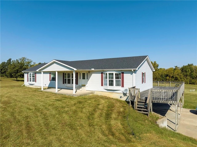 view of front facade with a wooden deck and a front yard