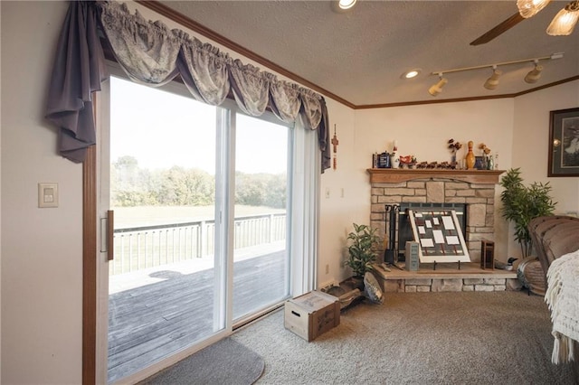 carpeted living room featuring a water view, ceiling fan, a fireplace, ornamental molding, and a textured ceiling