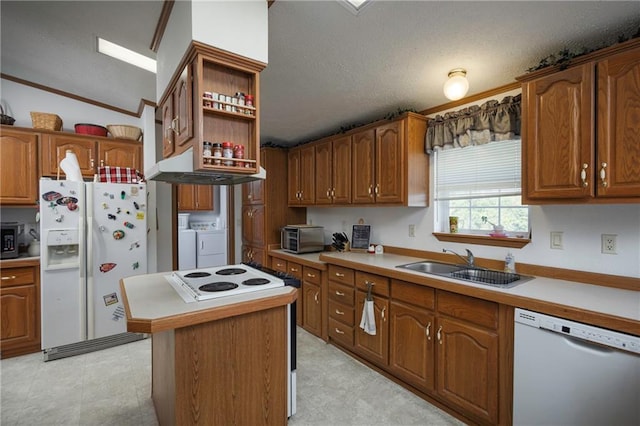 kitchen with lofted ceiling, separate washer and dryer, a center island, white appliances, and sink