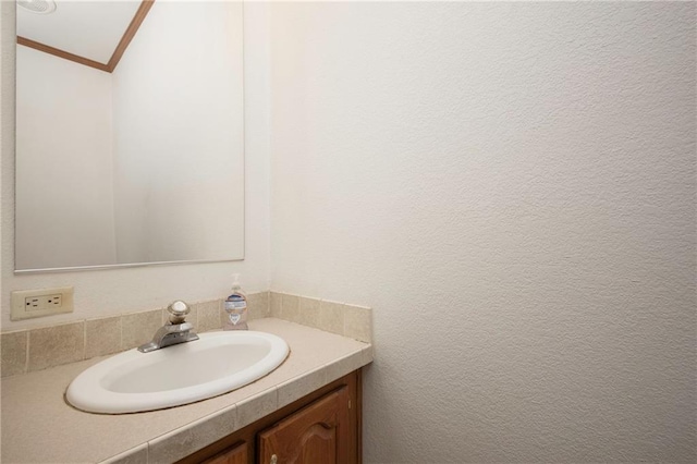 bathroom featuring ornamental molding, vanity, and vaulted ceiling