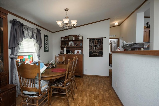 dining area featuring a notable chandelier, hardwood / wood-style flooring, lofted ceiling, and ornamental molding