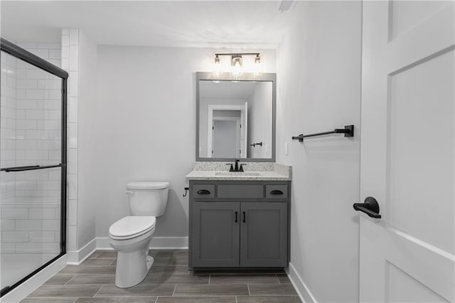 bathroom featuring vanity, toilet, and an enclosed shower