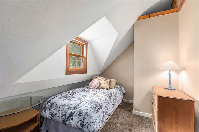 bedroom featuring lofted ceiling and dark carpet