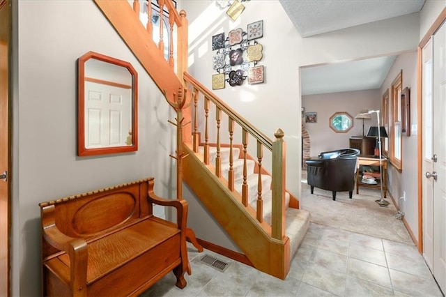 stairway with tile patterned floors