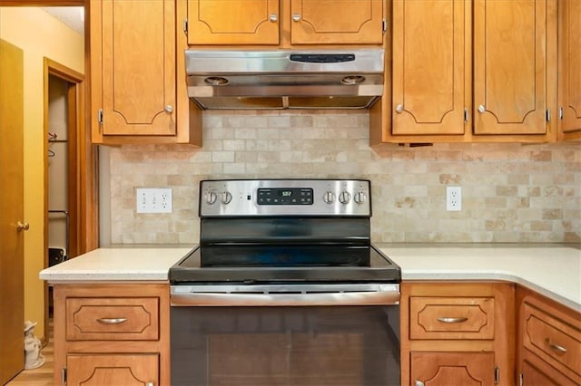 kitchen with stainless steel electric stove and backsplash