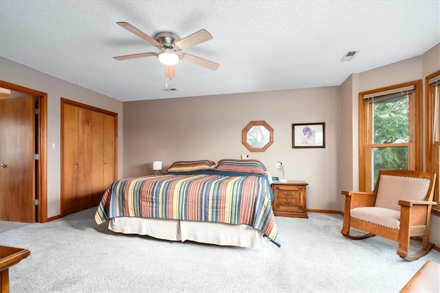 bedroom with ceiling fan, carpet flooring, and a textured ceiling