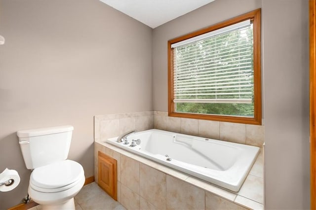 bathroom with toilet, tile patterned flooring, a wealth of natural light, and tiled bath