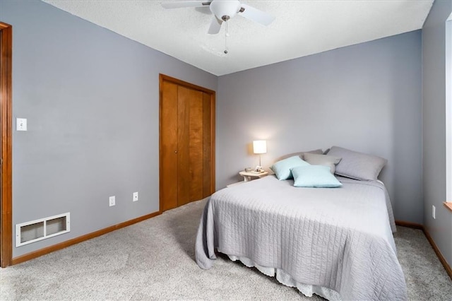 carpeted bedroom featuring a closet and ceiling fan