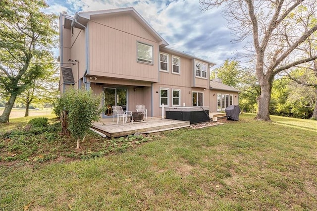 rear view of house featuring a yard, a hot tub, and a wooden deck