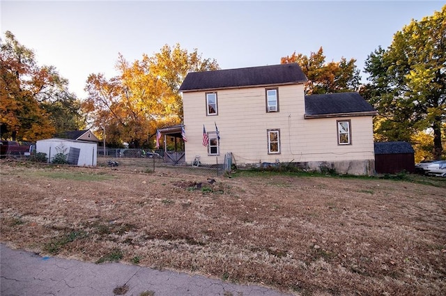 929 N 7th St, Atchison, KS 66002 - view of home's exterior with fence, a storage unit, and an outbuilding