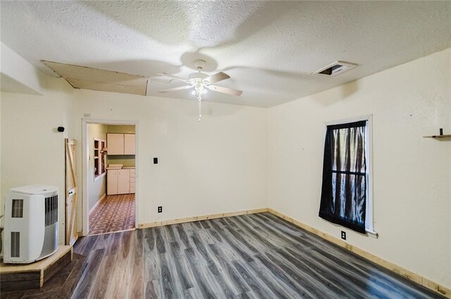 929 N 7th St, Atchison, KS 66002 - empty room with wood finished floors, a ceiling fan, a textured ceiling, and baseboards
