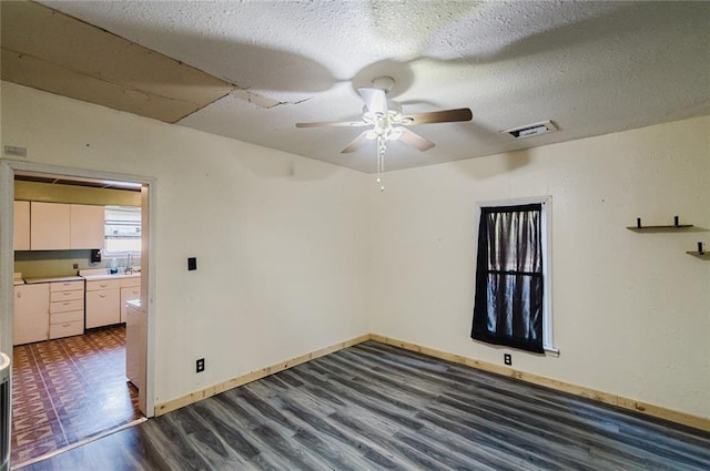 929 N 7th St, Atchison, KS 66002 - unfurnished room with wood finished floors, ceiling fan, baseboards, a textured ceiling, and a sink