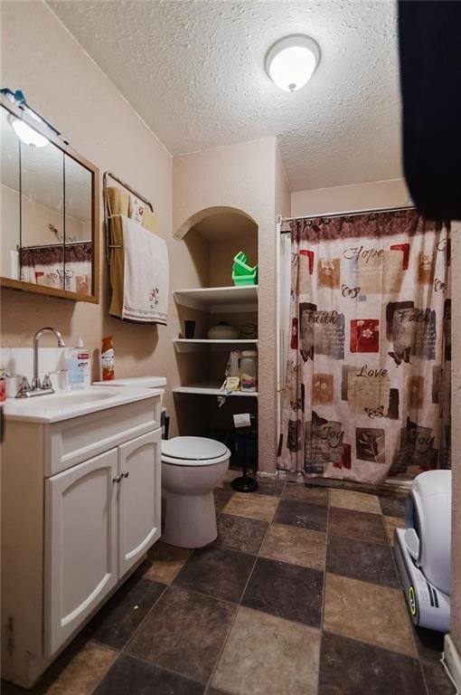 929 N 7th St, Atchison, KS 66002 - full bathroom featuring toilet, vanity, a textured ceiling, stone finish floors, and curtained shower