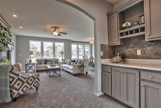 carpeted living room with ceiling fan