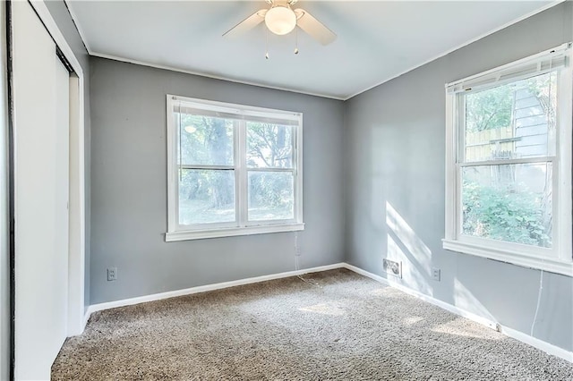 carpeted spare room featuring ceiling fan