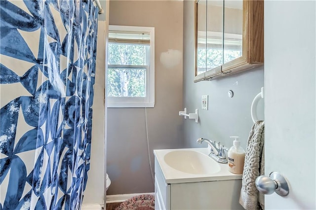 bathroom featuring a shower with curtain, vanity, and a healthy amount of sunlight