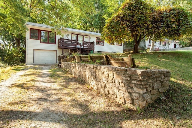 view of front of property with a front yard, a deck, and a garage