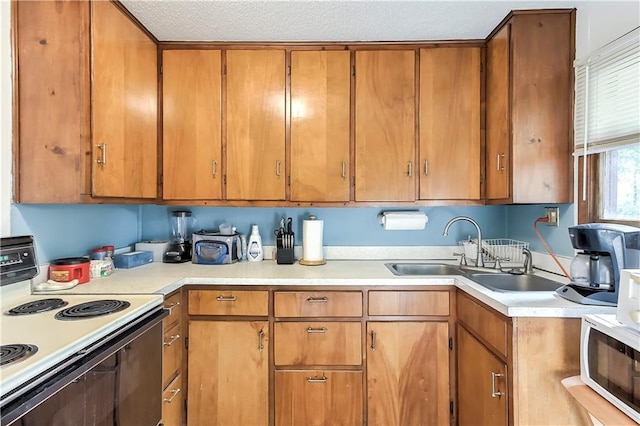 kitchen featuring sink, white appliances, and a textured ceiling