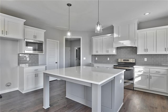 kitchen featuring premium range hood, stainless steel appliances, decorative light fixtures, and white cabinets