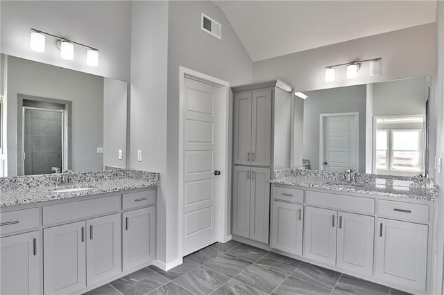 bathroom with vanity, lofted ceiling, and an enclosed shower