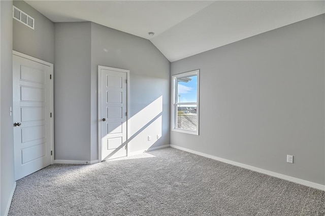 unfurnished bedroom featuring vaulted ceiling and carpet flooring