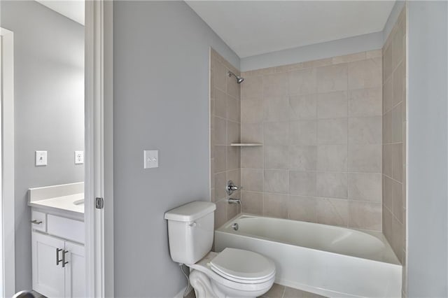 full bathroom featuring tiled shower / bath combo, vanity, tile patterned floors, and toilet