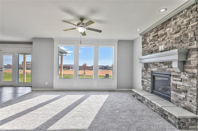 living room featuring ceiling fan, a fireplace, light colored carpet, and a healthy amount of sunlight