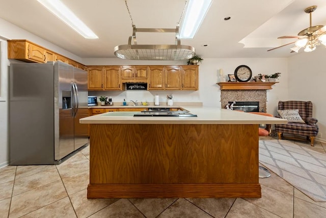 kitchen with ceiling fan, sink, stainless steel appliances, kitchen peninsula, and light tile patterned floors