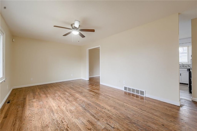 unfurnished room featuring ceiling fan, hardwood / wood-style floors, and sink