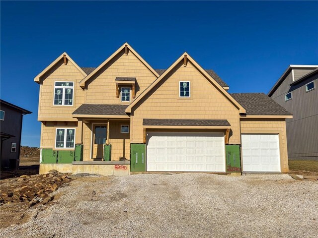 view of front of home with driveway and a shingled roof