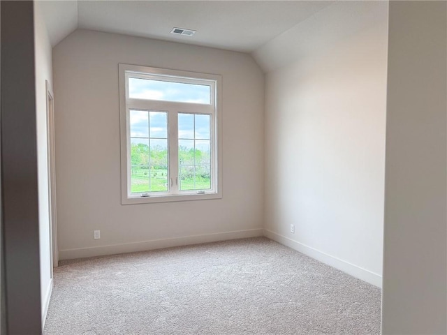 empty room with lofted ceiling, carpet flooring, and baseboards