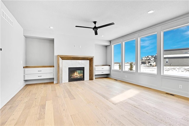 unfurnished living room featuring wood finished floors, a ceiling fan, a fireplace, baseboards, and recessed lighting