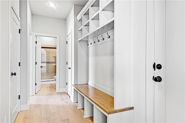 mudroom with light wood-style flooring and baseboards