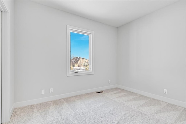 empty room featuring carpet and baseboards