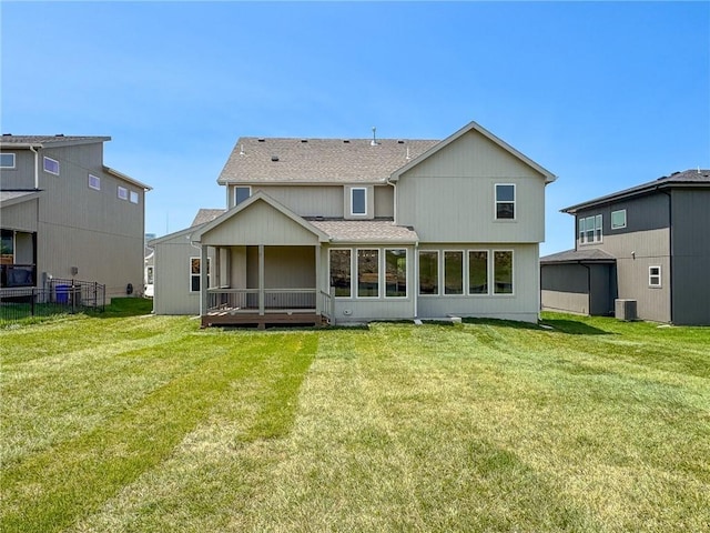 22070 W 100th Ter, Lenexa, KS 66220 - back of property featuring a shingled roof, a sunroom, and a yard