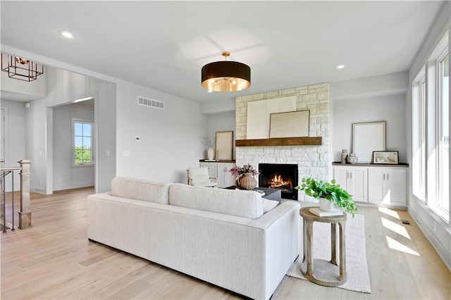 22070 W 100th Ter, Lenexa, KS 66220 - living room with light wood-style flooring, a stone fireplace, and recessed lighting