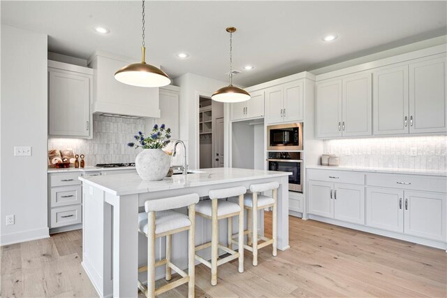 22070 W 100th Ter, Lenexa, KS 66220 - kitchen featuring appliances with stainless steel finishes, backsplash, light countertops, light wood finished floors, and recessed lighting
