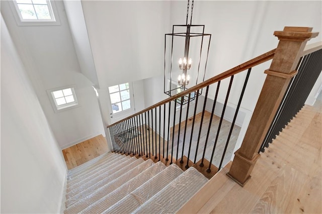 22070 W 100th Ter, Lenexa, KS 66220 - stairs featuring wood finished floors, plenty of natural light, a chandelier, and a high ceiling
