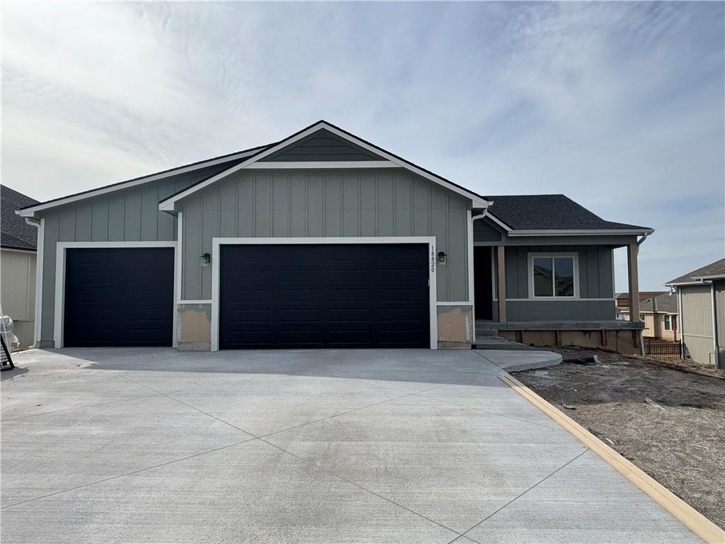 ranch-style house with driveway, roof with shingles, and an attached garage