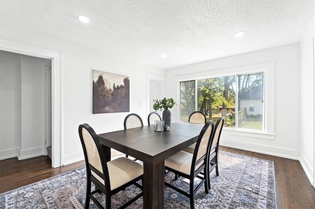 dining room with a textured ceiling and dark hardwood / wood-style flooring