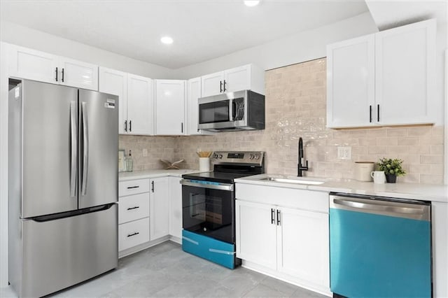 kitchen featuring appliances with stainless steel finishes, decorative backsplash, white cabinets, and sink