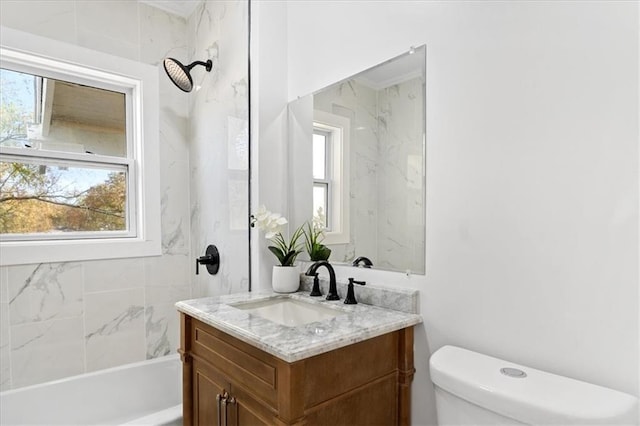 full bathroom featuring tiled shower / bath, vanity, and toilet