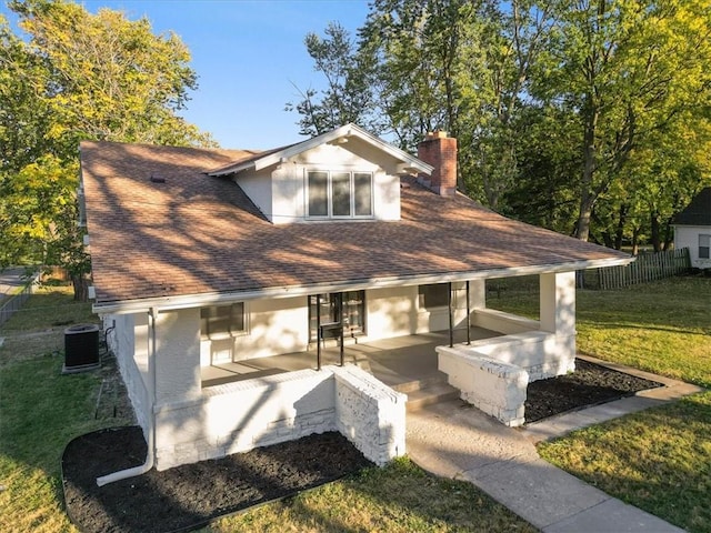 view of front of house featuring central air condition unit, a patio area, and a front yard