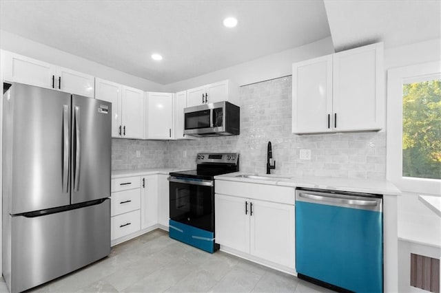 kitchen featuring white cabinetry, appliances with stainless steel finishes, sink, and decorative backsplash