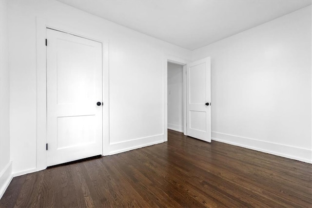 unfurnished bedroom featuring dark hardwood / wood-style floors and a closet