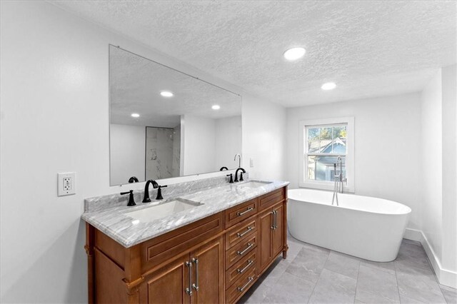 bathroom featuring vanity, a textured ceiling, shower with separate bathtub, and tile patterned flooring