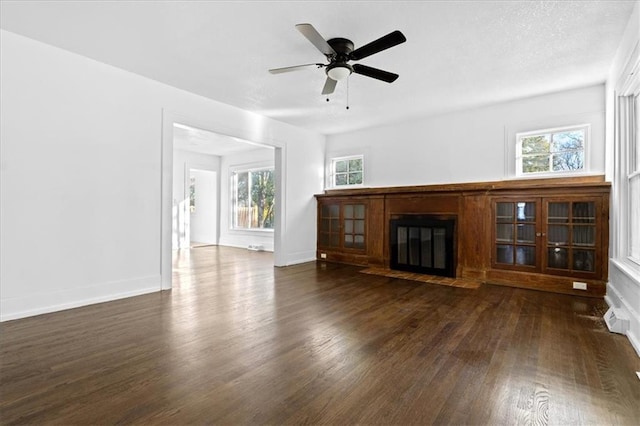 unfurnished living room featuring ceiling fan and dark hardwood / wood-style floors